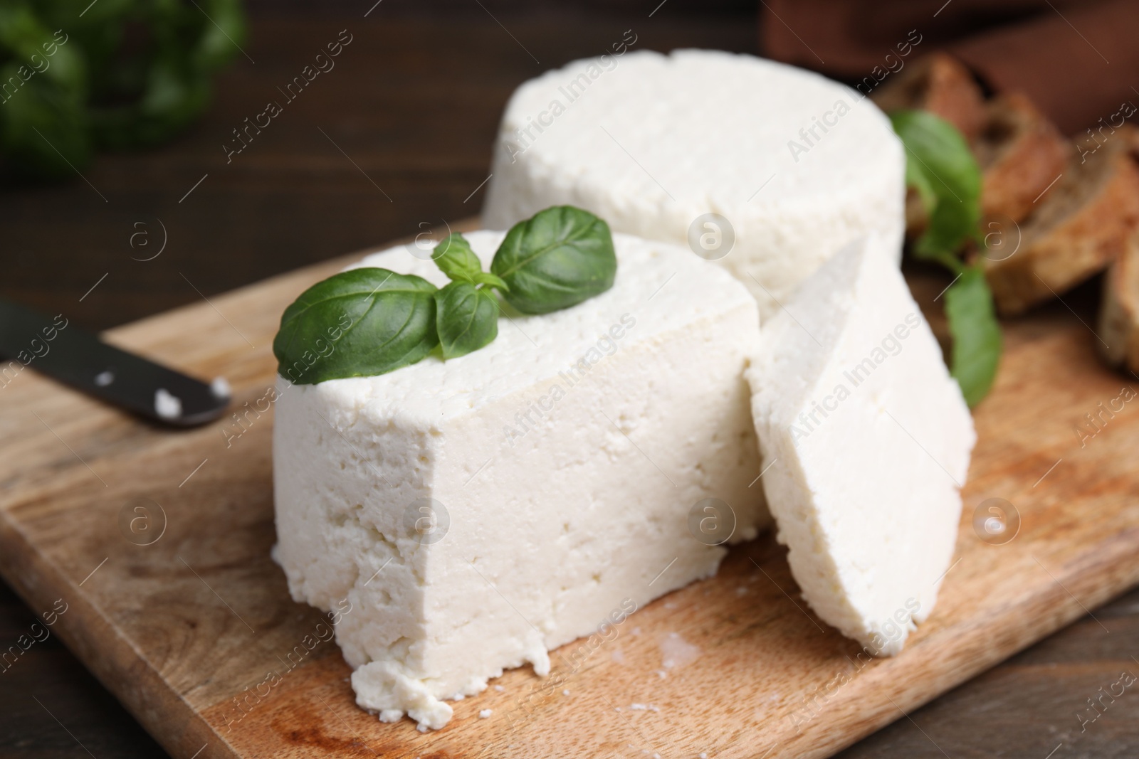 Photo of Fresh ricotta (cream cheese) and basil on table, closeup