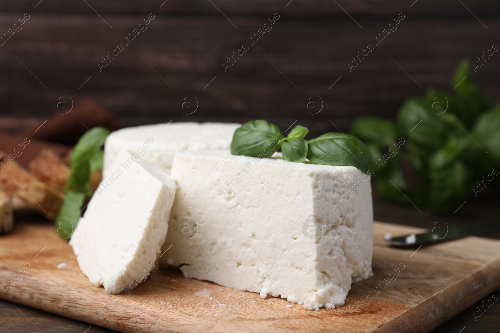 Photo of Fresh ricotta (cream cheese) and basil on table, closeup