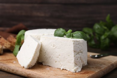 Fresh ricotta (cream cheese) and basil on table, closeup