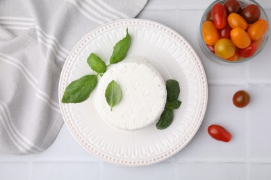 Photo of Fresh ricotta (cream cheese), basil and tomatoes on light tiled table, flat lay