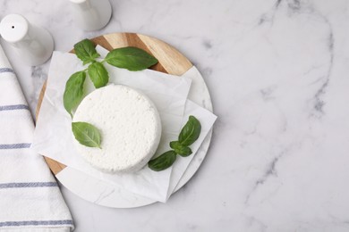 Photo of Fresh ricotta (cream cheese), basil and spices on light marble table, flat lay. Space for text