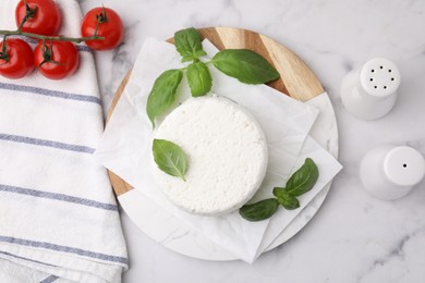 Photo of Fresh ricotta (cream cheese), basil, spices and tomatoes on light marble table, flat lay