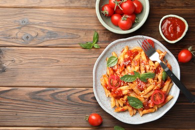 Photo of Delicious pasta with tomato sauce, basil and cheese served on wooden table, flat lay. Space for text