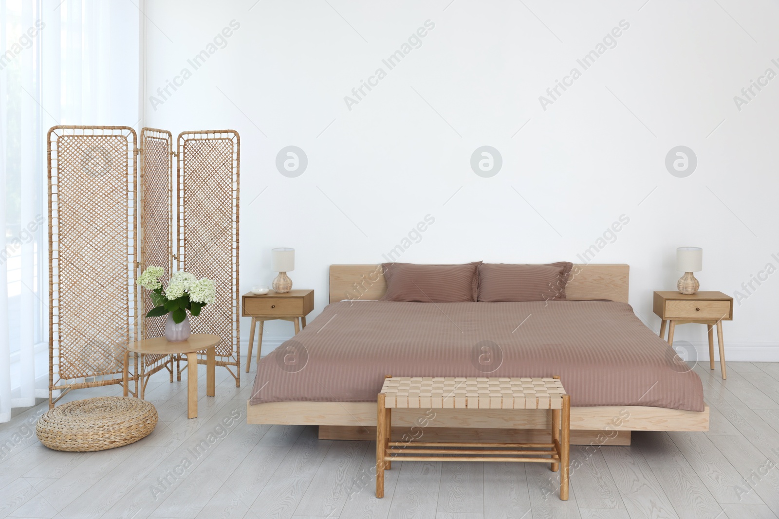 Photo of Folding screen, comfortable bed, ottoman and bedside tables in room