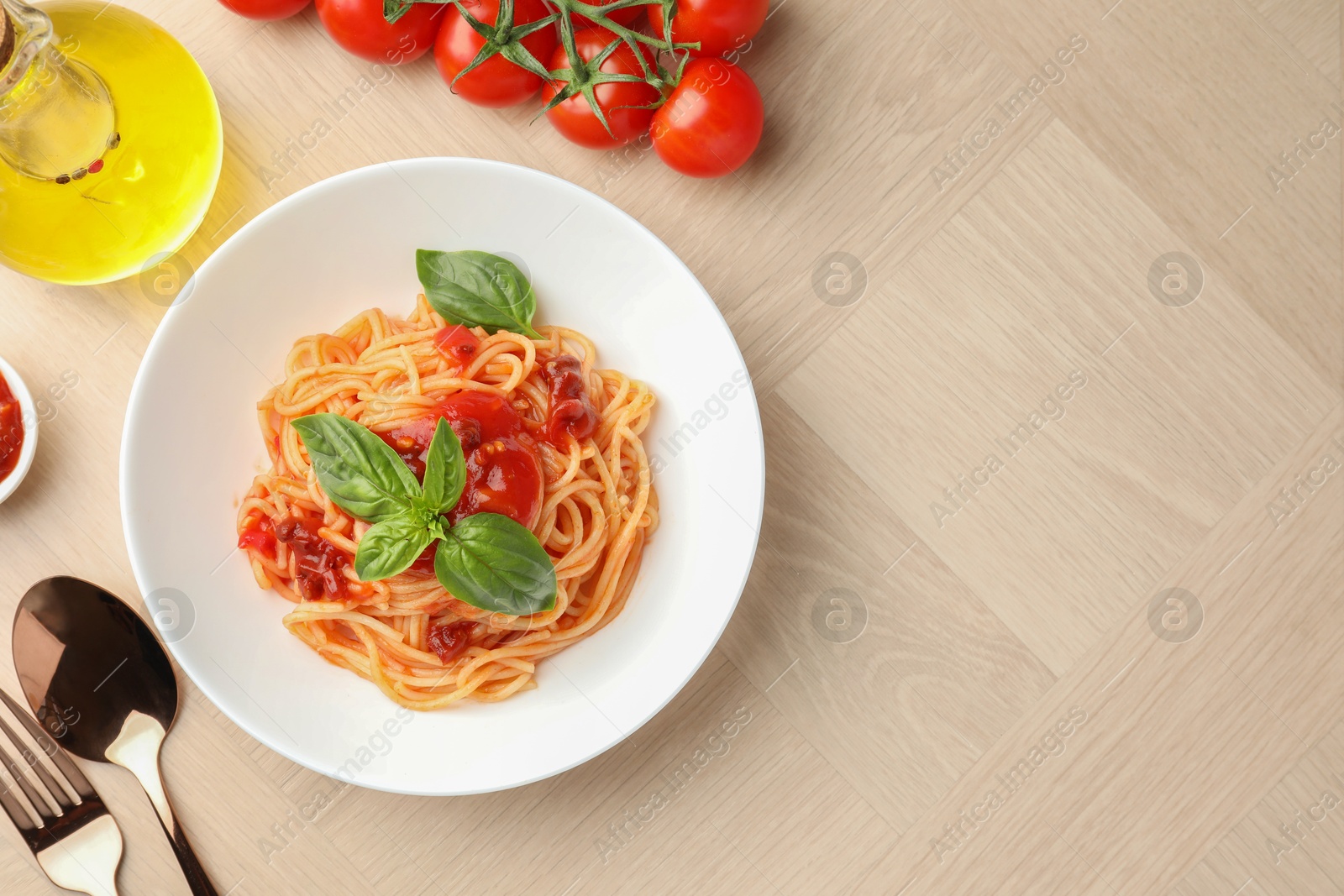 Photo of Delicious pasta with tomato sauce and basil in bowl on wooden table, flat lay. Space for text