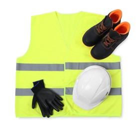 Photo of Reflective vest, pair of working boots, hard hat and protective gloves isolated on white, top view