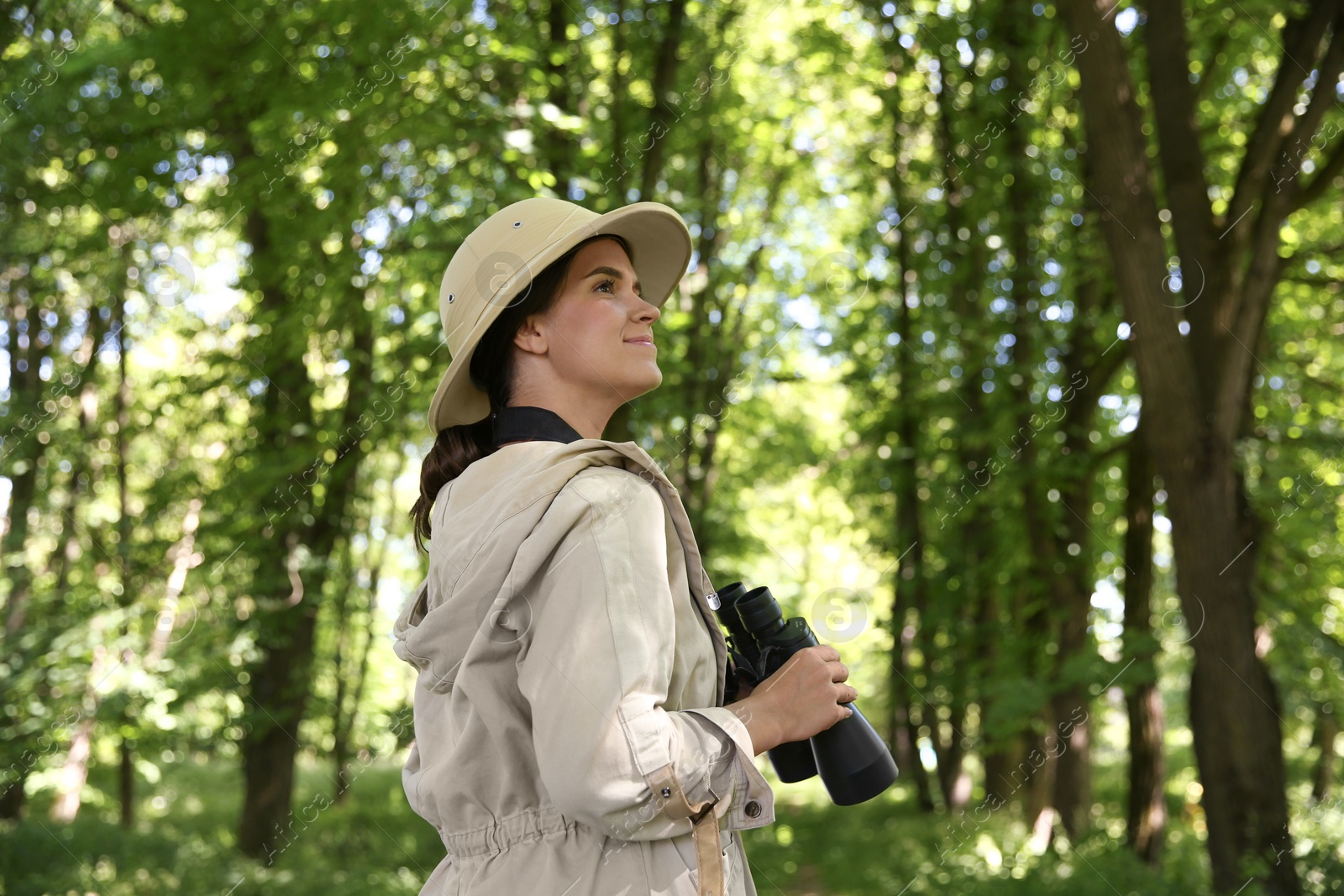 Photo of Forester with binoculars examining plants in forest