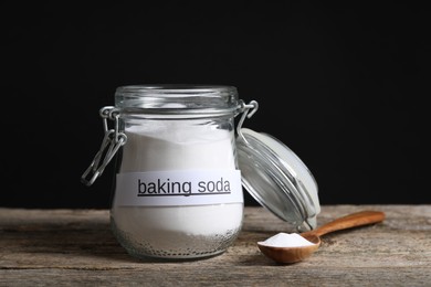 Baking soda in glass jar and spoon on wooden table