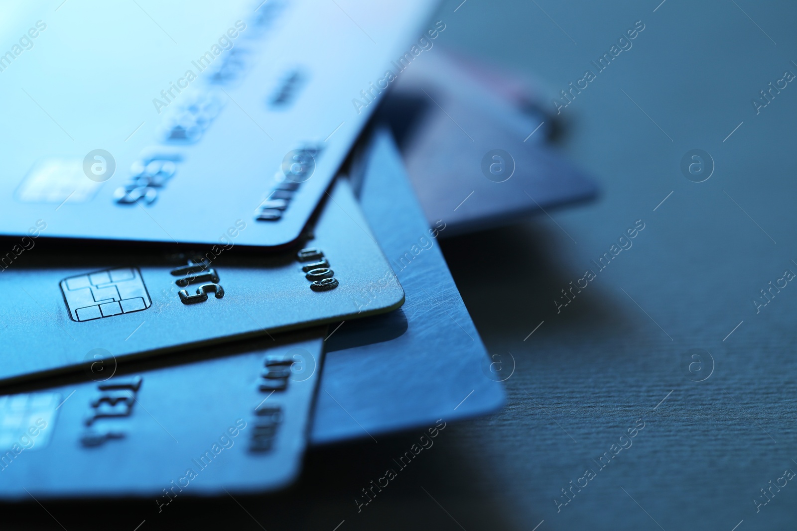 Photo of Many credit cards on dark background, closeup