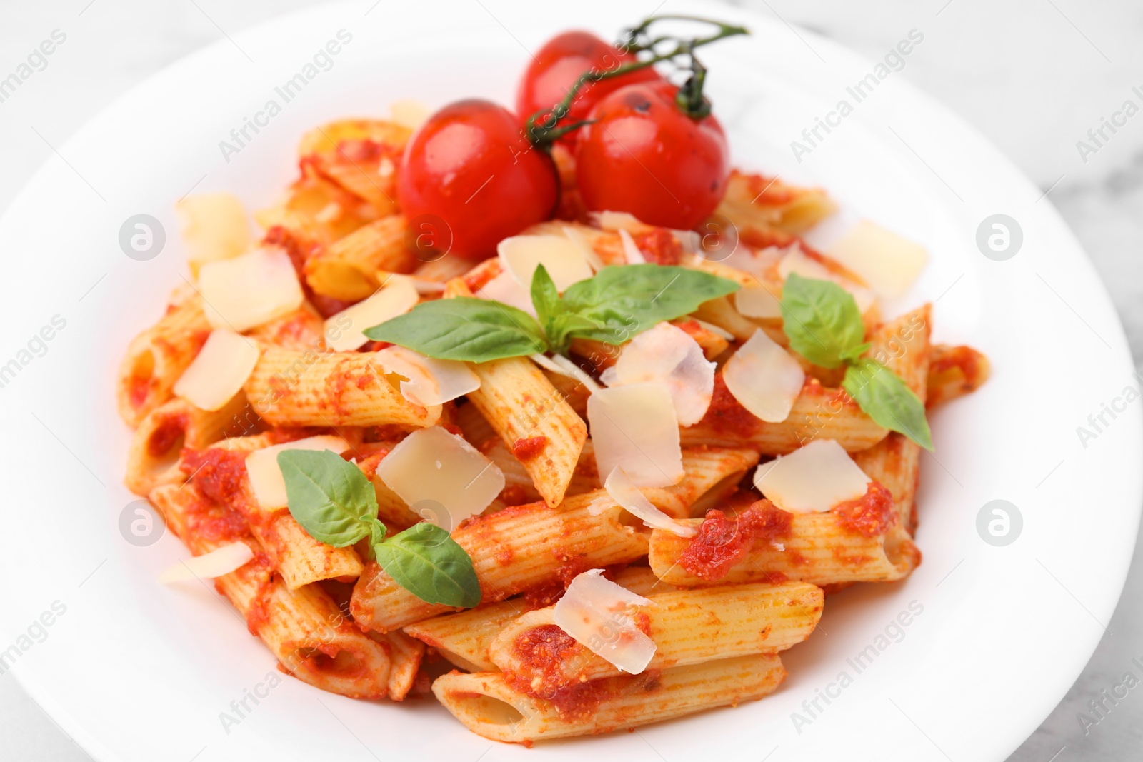 Photo of Tasty pasta with tomato sauce, cheese and basil on table, closeup