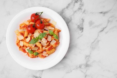 Photo of Tasty pasta with tomato sauce, cheese and basil on white marble table, top view. Space for text