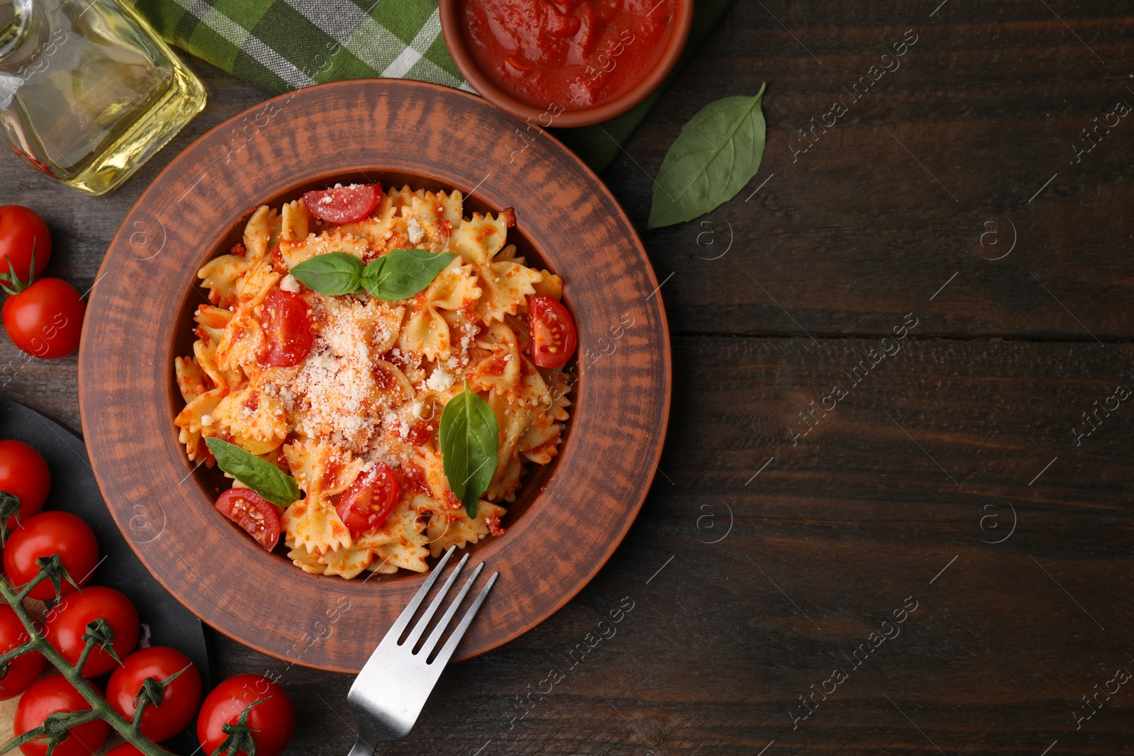 Photo of Tasty pasta with tomato sauce, cheese and fork on wooden table, flat lay. Space for text