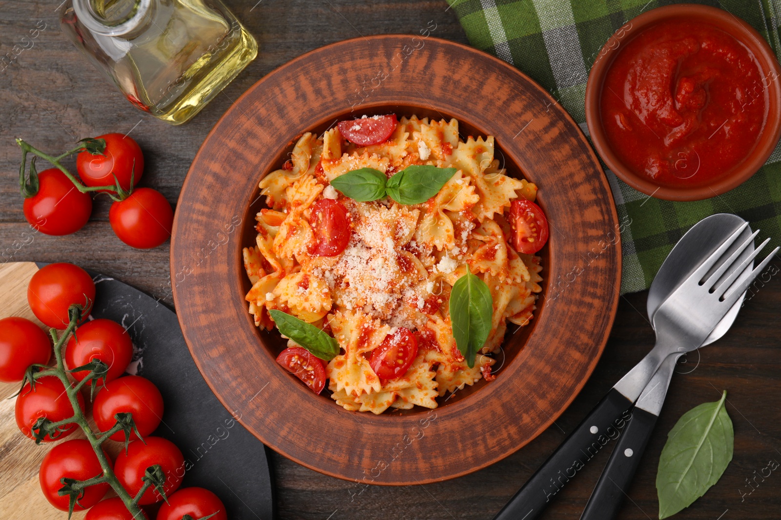 Photo of Tasty pasta with tomato sauce, cheese and basil served on wooden table, flat lay