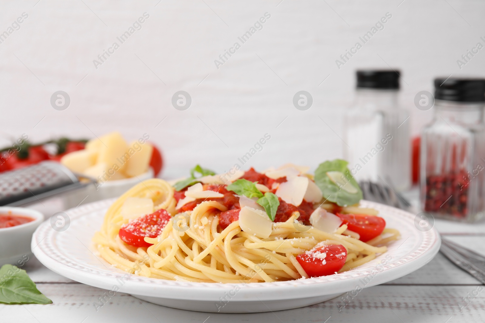 Photo of Tasty pasta with tomato sauce, cheese and basil on white table, closeup