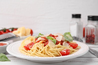 Tasty pasta with tomato sauce, cheese and basil on white table, closeup