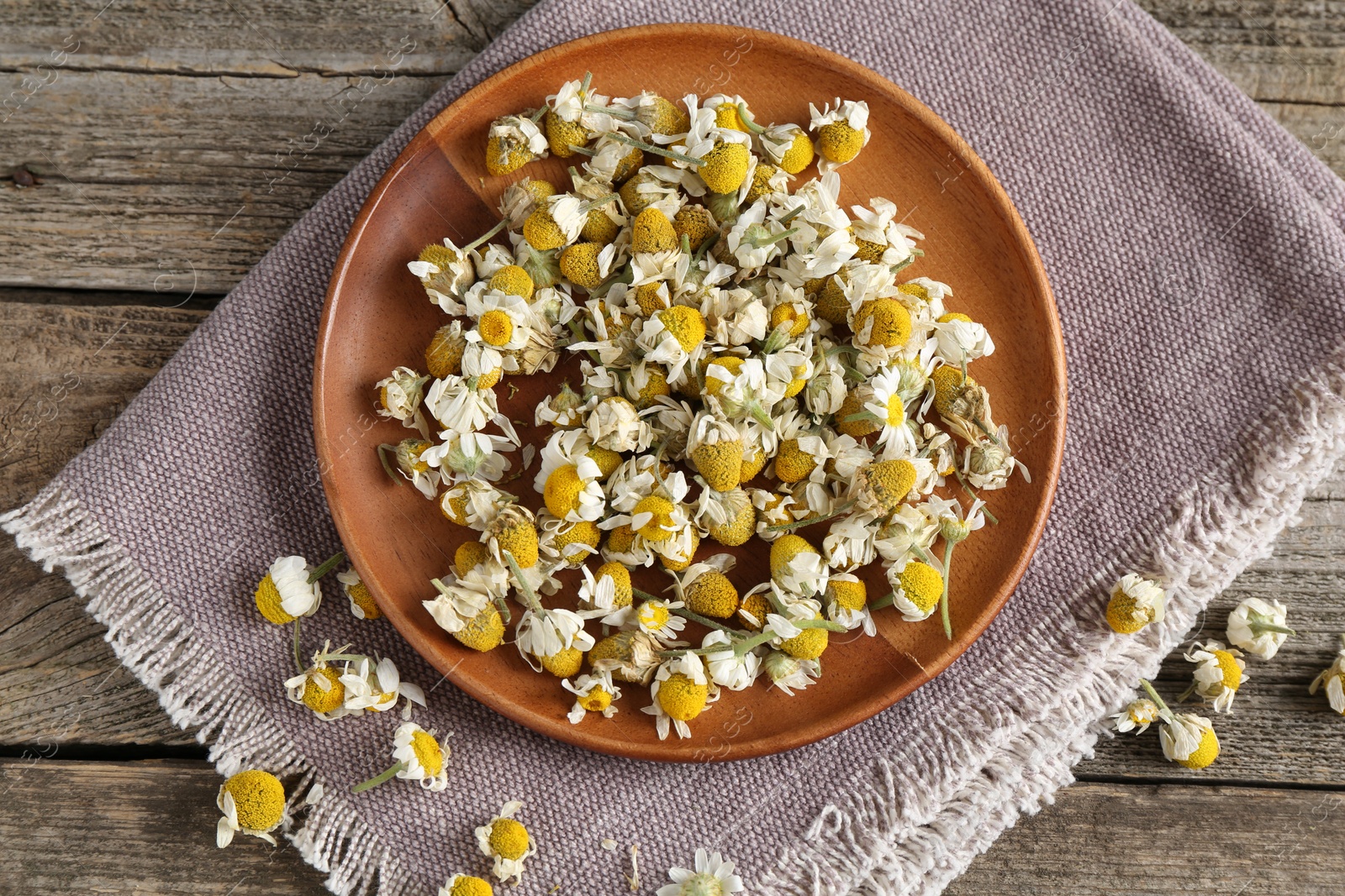 Photo of Chamomile flowers on wooden table, top view