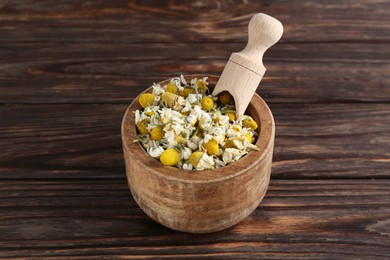 Dry and fresh chamomile flowers with scoop in bowl on white wooden table