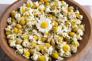 Dry and fresh chamomile flowers in bowl, closeup