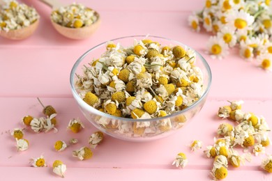 Chamomile flowers in glass bowl on pink wooden table