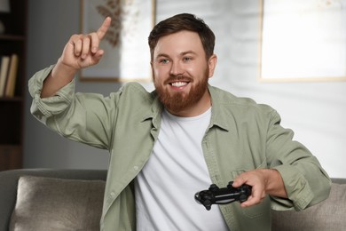 Happy man with game controller at home