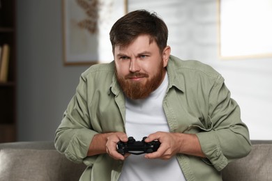 Emotional man with game controller at home