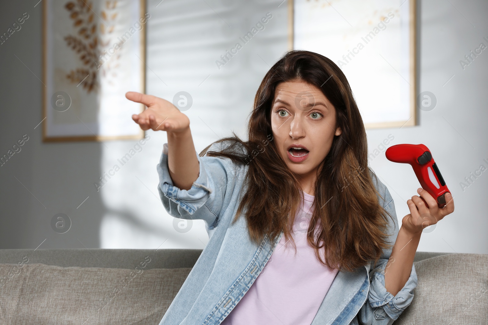 Photo of Confused woman with game controller at home