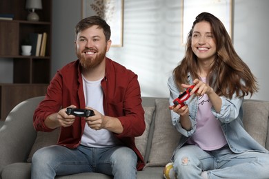 Couple playing video game with controllers at home
