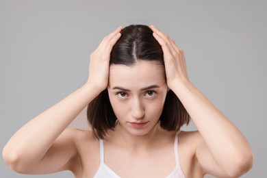 Photo of Sad woman with hair loss problem on grey background