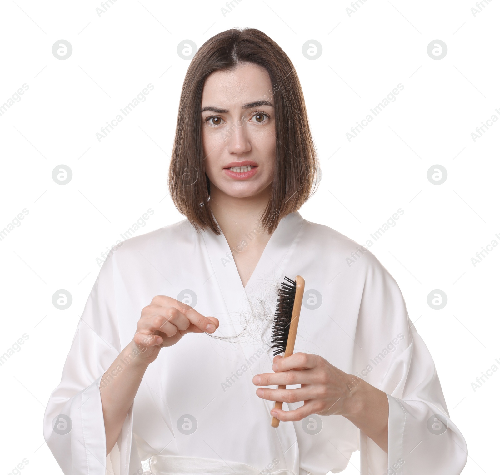 Photo of Emotional woman taking her lost hair from brush on white background. Alopecia problem