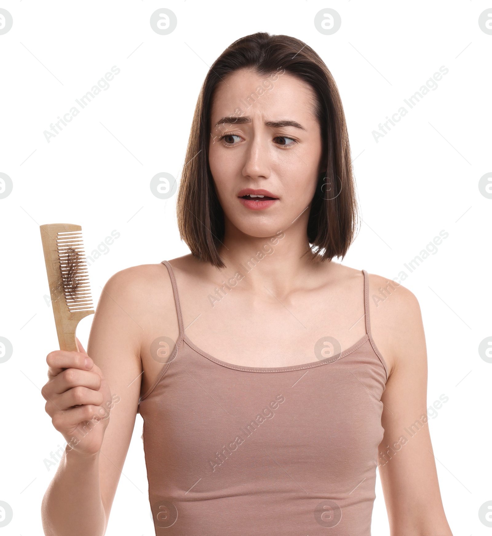 Photo of Stressed woman holding comb with lost hair on white background. Alopecia problem