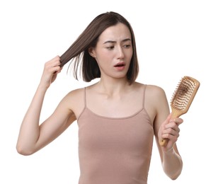 Sad woman holding brush with lost hair on white background. Alopecia problem