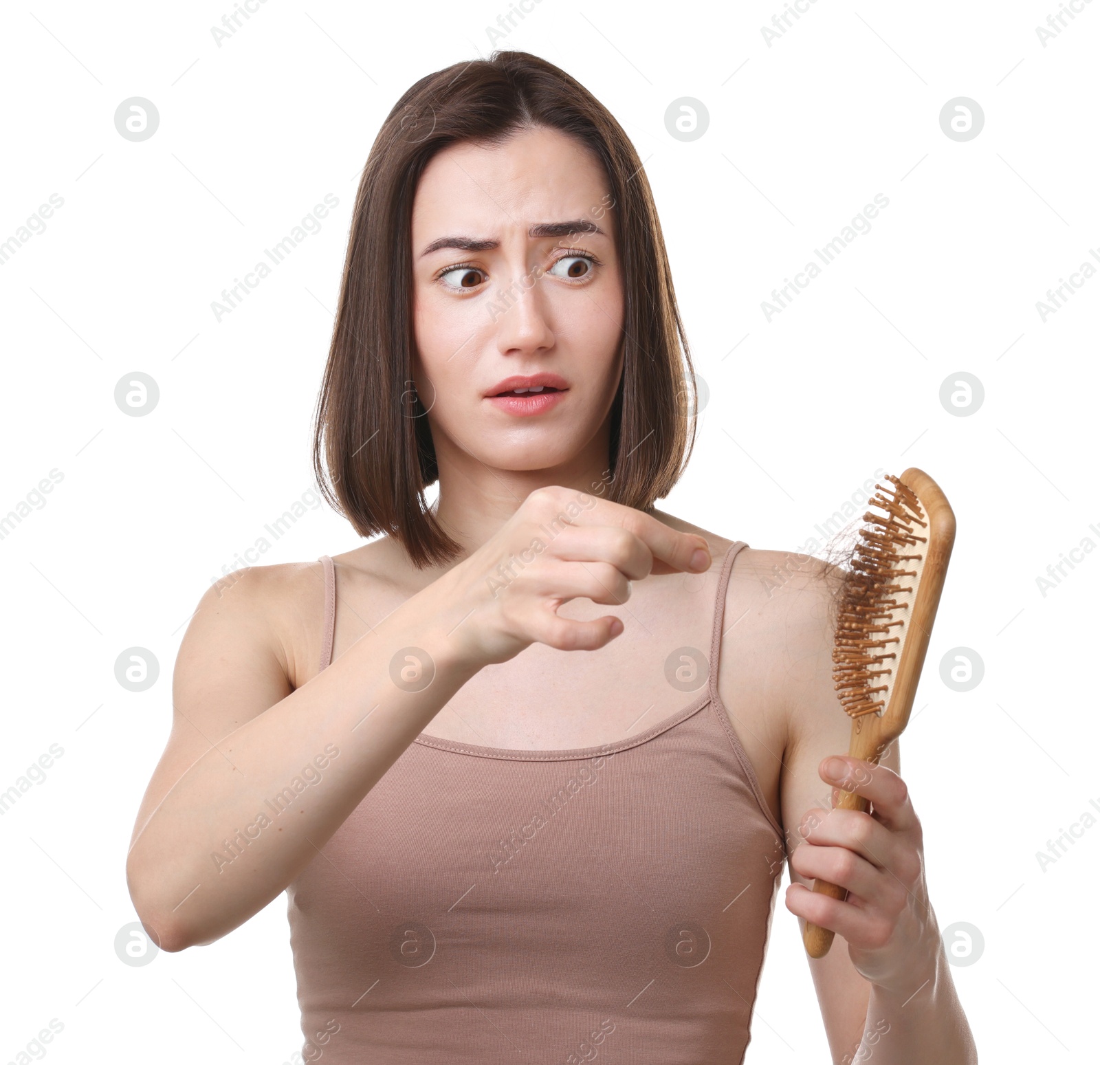 Photo of Emotional woman taking her lost hair from brush on white background. Alopecia problem