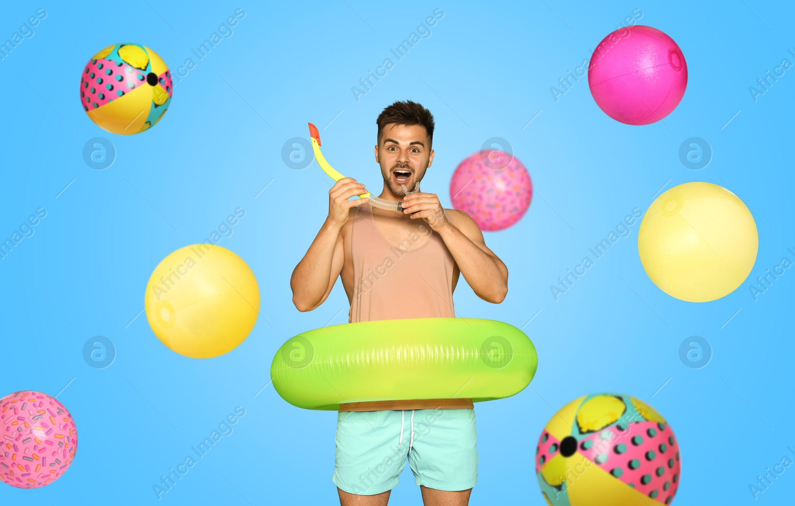 Image of Happy man with inflatable ring among falling beach balls on light blue background. Summer vibe