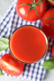 Photo of Fresh tomato juice in glass on light table, top view