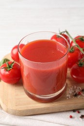 Photo of Tasty tomato juice in glass with fresh vegetables and spices on white table, closeup