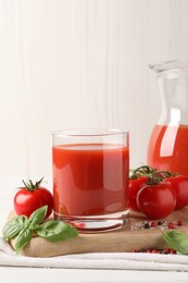 Tasty tomato juice with fresh vegetables and spices on white table