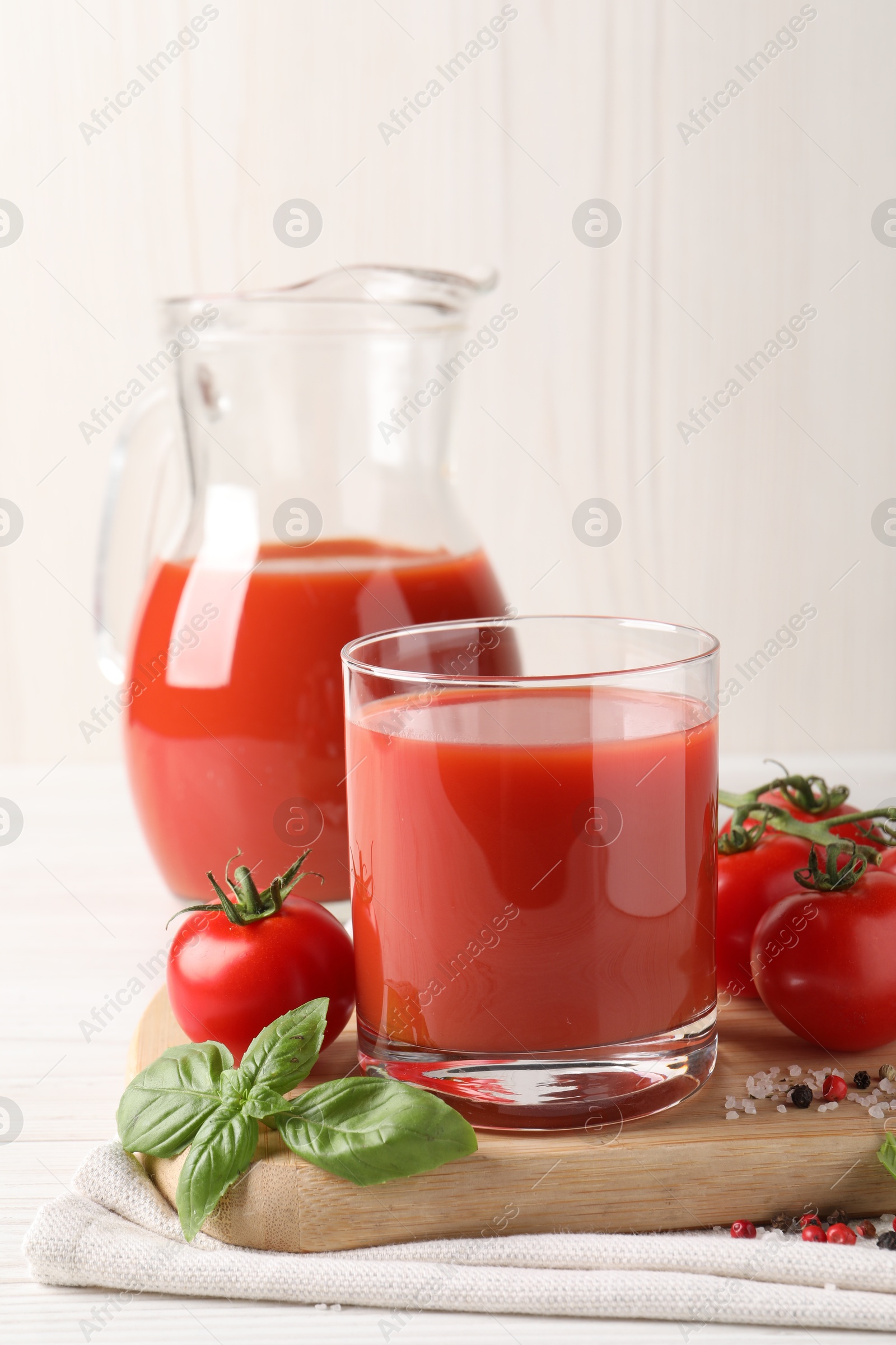 Photo of Tasty tomato juice with fresh vegetables and spices on white table