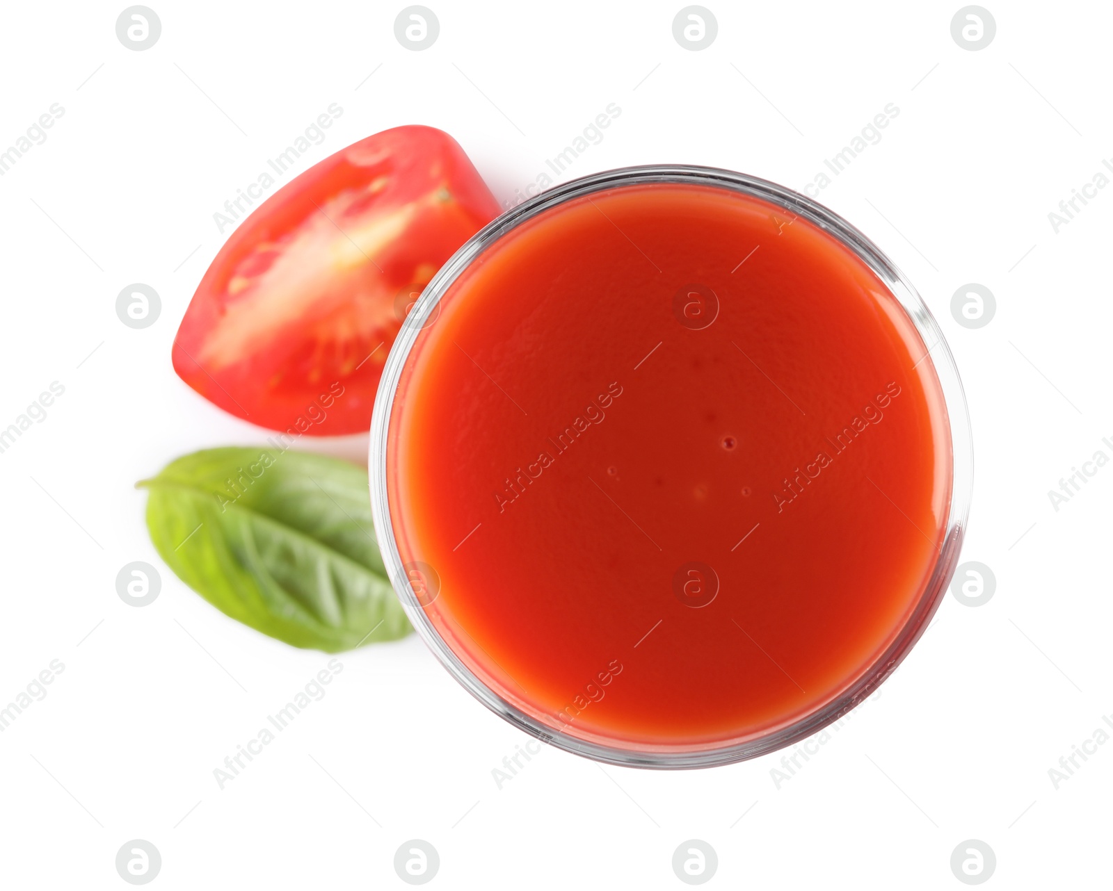 Photo of Tasty tomato juice in glass, basil leaf and fresh vegetable isolated on white, top view