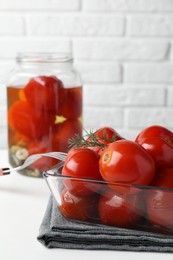 Photo of Tasty pickled tomatoes and dill in bowl on white table