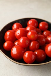 Tasty pickled tomatoes in bowl on light grey table