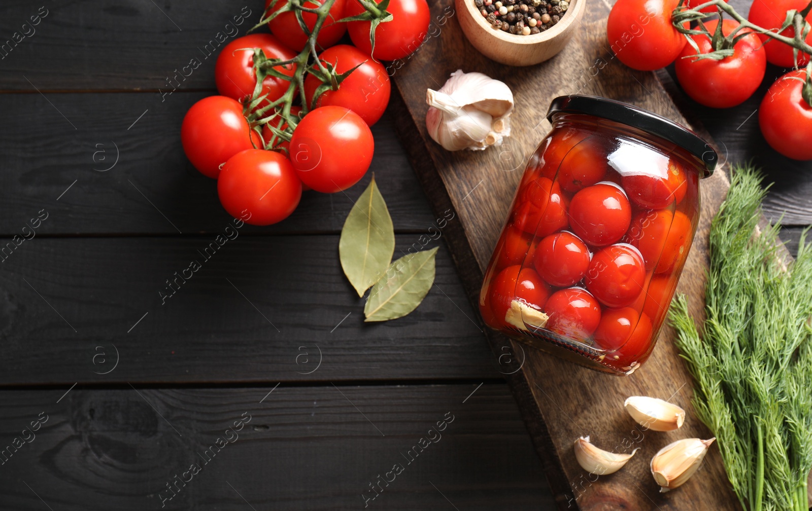 Photo of Tasty pickled tomatoes in jar, spices and fresh vegetables on grey wooden table, top view. Space for text