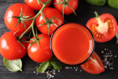 Fresh tomato juice in glass on black table, top view