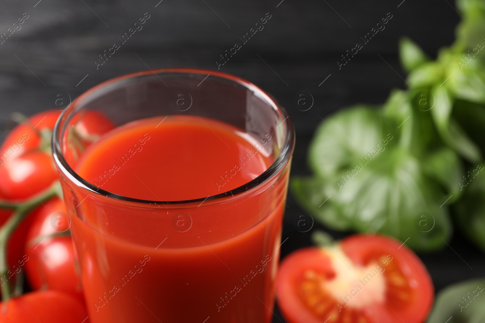 Photo of Fresh tomato juice in glass on table, closeup