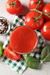 Tasty tomato juice in glass, spices and fresh vegetables on light table, flat lay