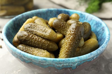 Photo of Pickled cucumbers in bowl on grey table, closeup