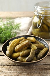 Photo of Pickled cucumbers in bowl on wooden table