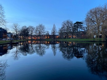 Scenic view of river and buildings on shore in evening