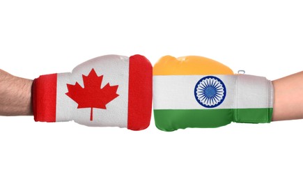 Image of Political conflict. Men in boxing gloves with flags of Canada and India fighting on white background, closeup