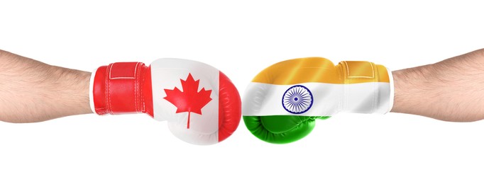 Image of Political conflict. Men in boxing gloves with flags of Canada and India fighting on white background, closeup