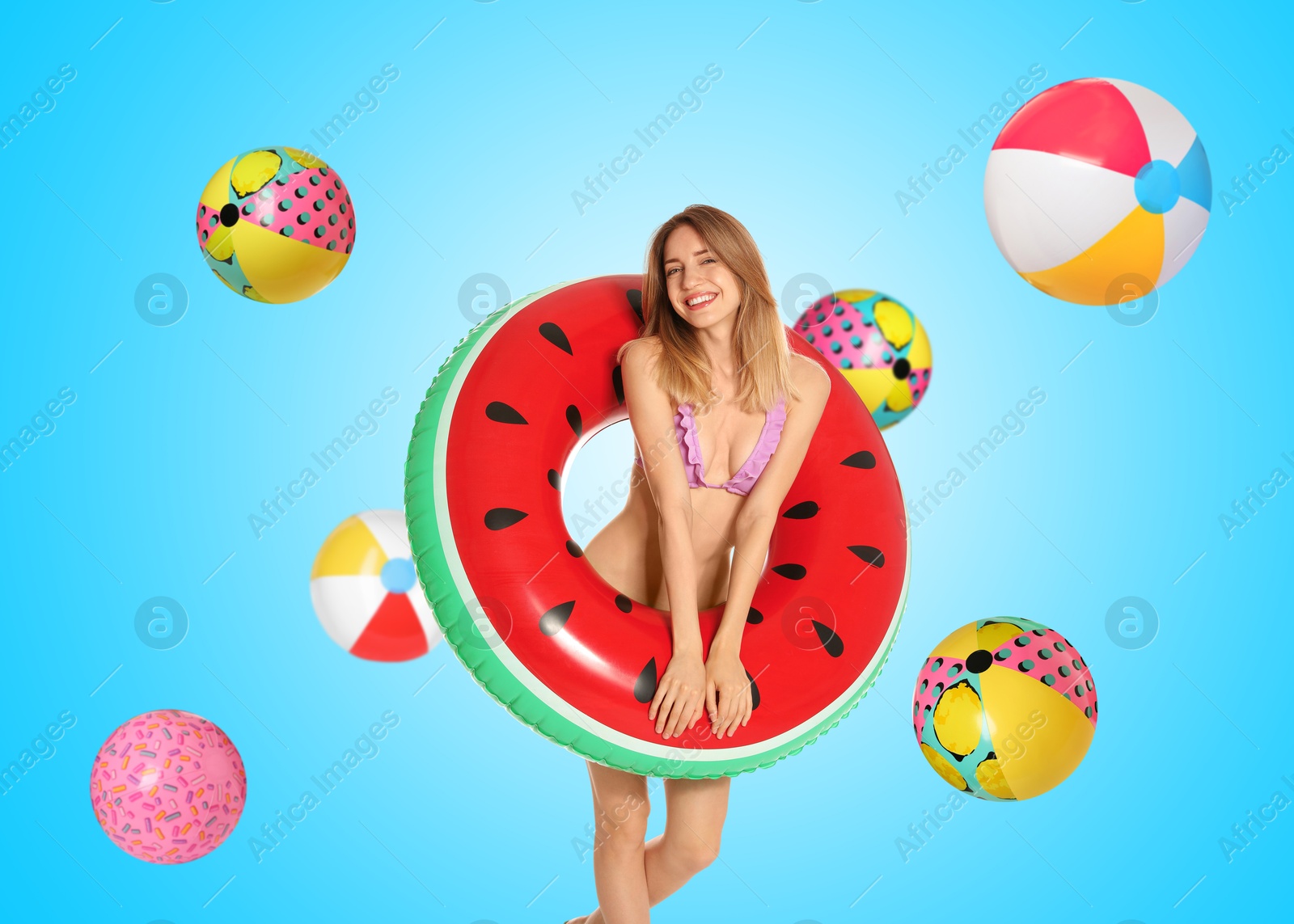 Image of Happy woman with inflatable ring among falling beach balls on light blue background. Summer vibe